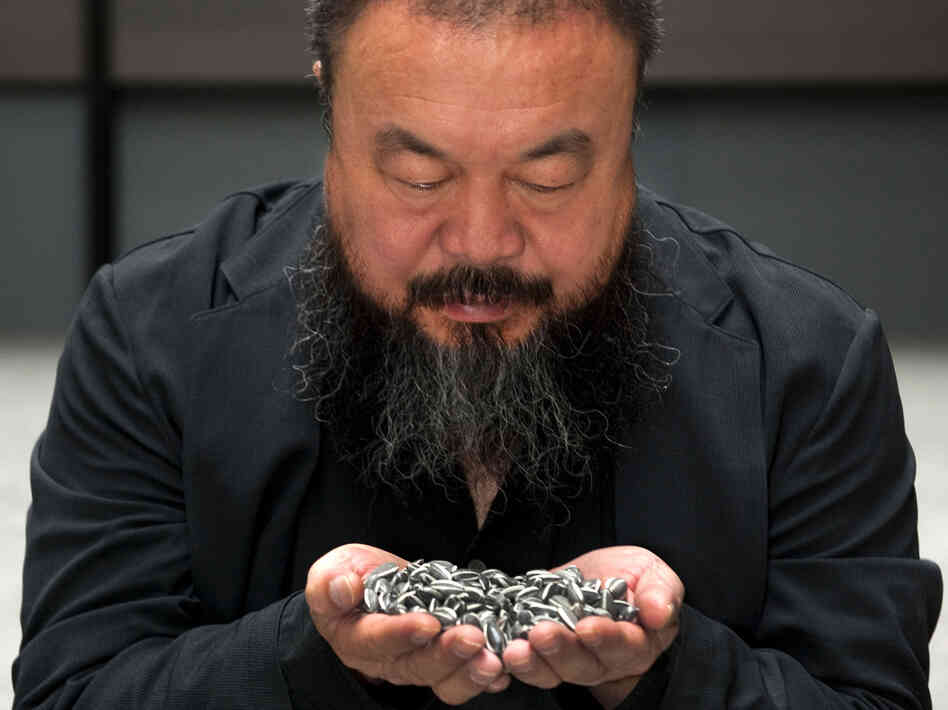 Artist Ai Weiwei holds porcelain sunflower seeds from his installation