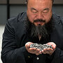 Artist Ai Weiwei holds porcelain sunflower seeds from his installation