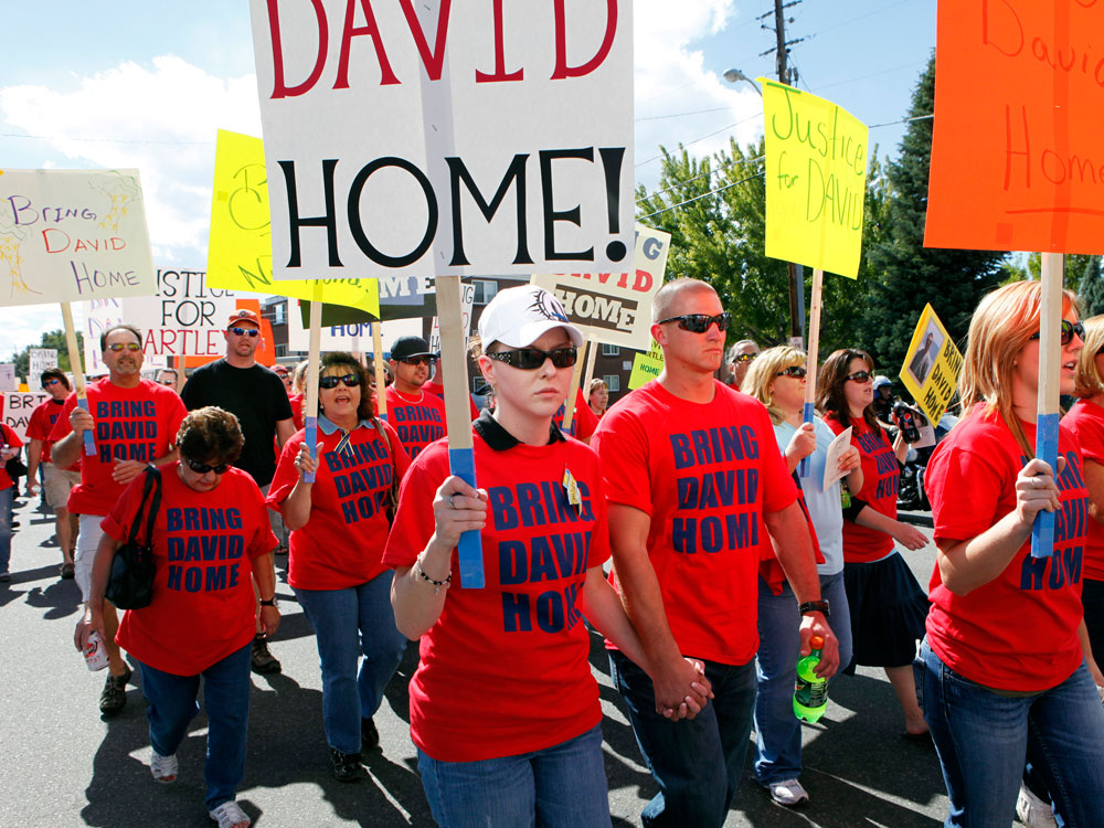 Friends and supporters of David Hartley march in an effort to have his body returned to the United States.