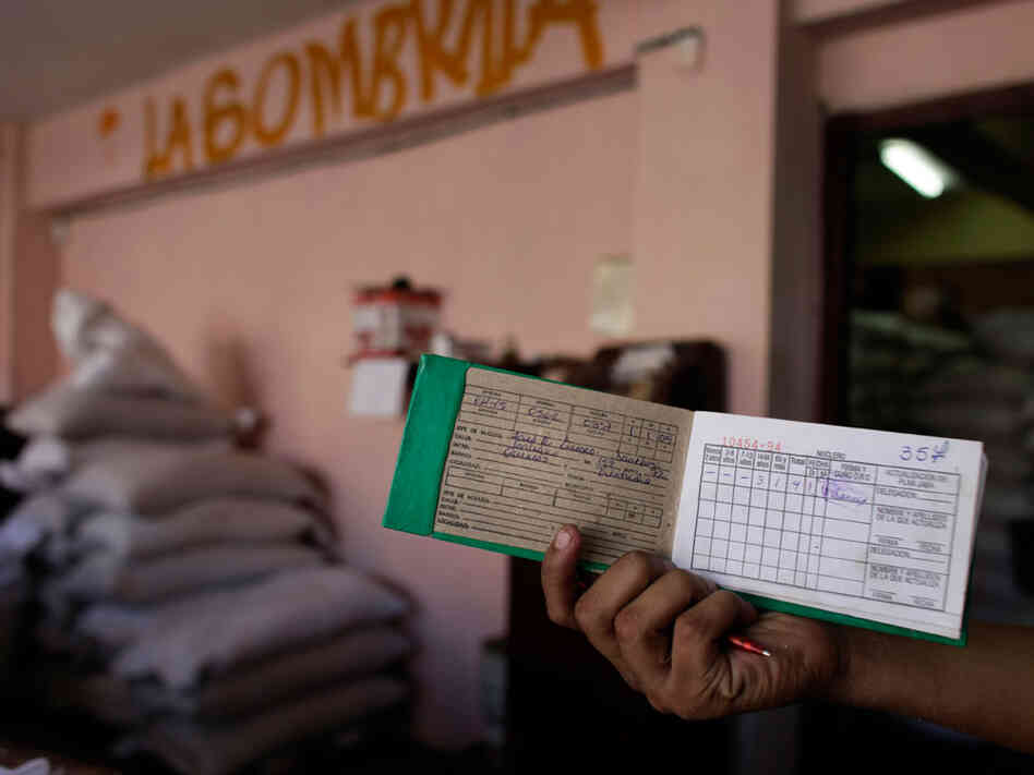 A customer displays his ration card as he waits to buy food at a government store in Havana in October 2009