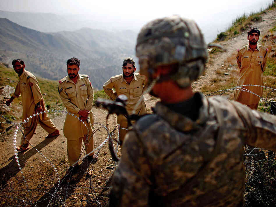 Army Lt. Kenneth Kovach speaks to Pakistani border police over wire that separates Afghanistan and Pakistan