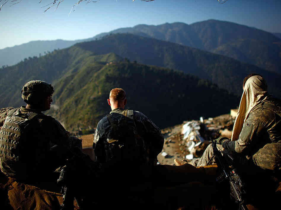 U.S. soldiers hold a security position for a team working on a disabled helicopter