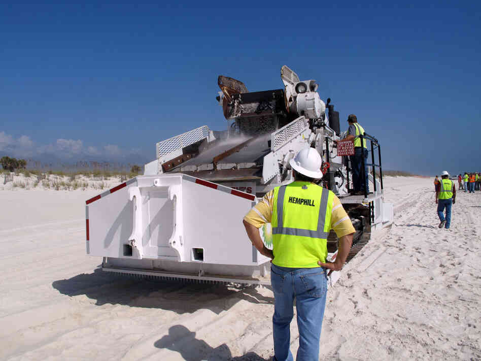 An earth-moving machine dubbed "Ozzie" digs up oily sand and sifts out the tar balls.