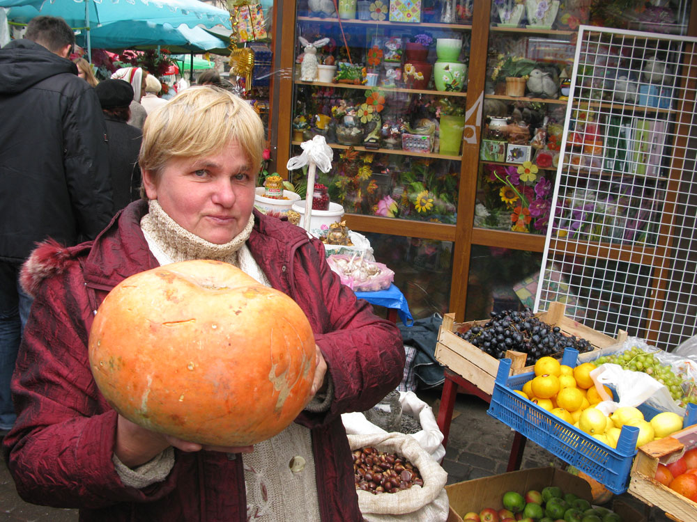 Vegetable seller Olesya Vladymyrovna holds a pumpkin