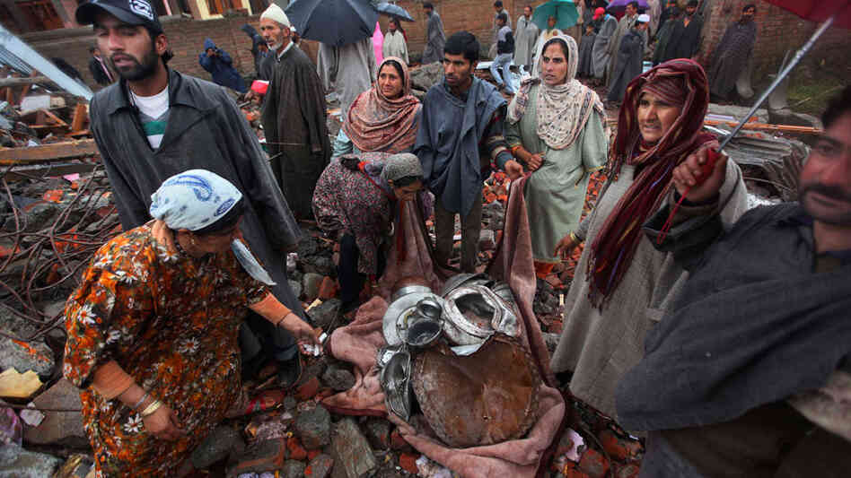 Kashmiris salvage their belongings after a gun battle between separatists and Indian troops
