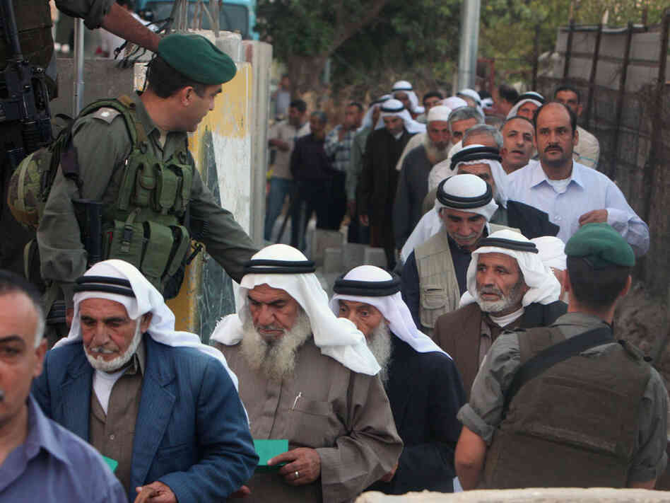 Palestinian men pass through an Israeli checkpoint in the West Bank town of Bethlehem