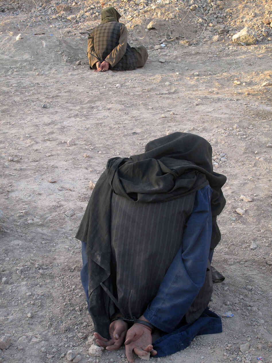 Afghan men are detained for questioning by U.S. soldiers. Afghan men are detained for questioning by U.S. soldiers.