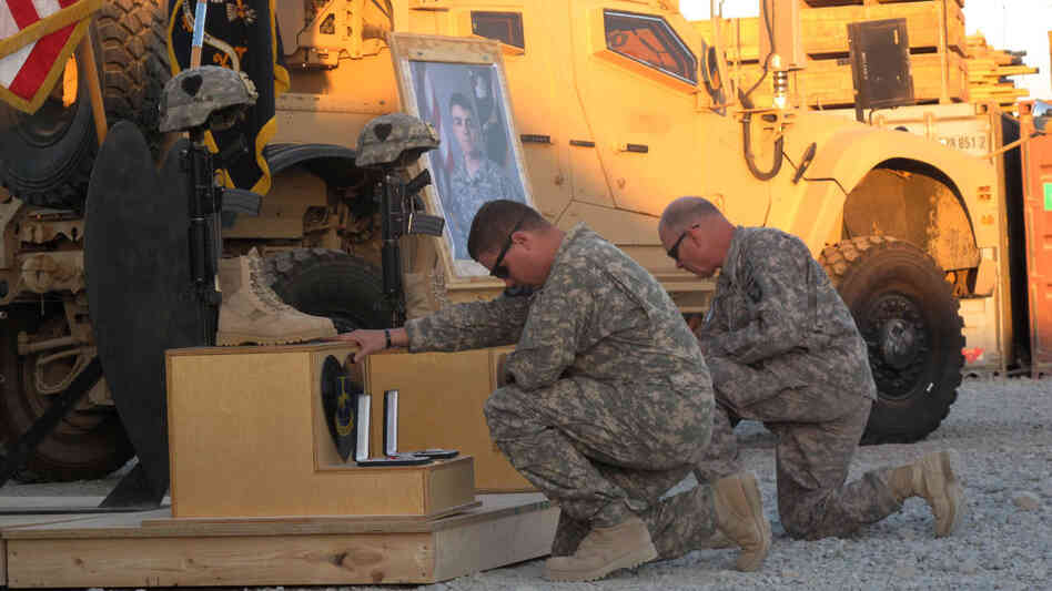 Members of the 101st Airborne Division grieve in front of the memorial displays for Specialist Jonathan Curtis