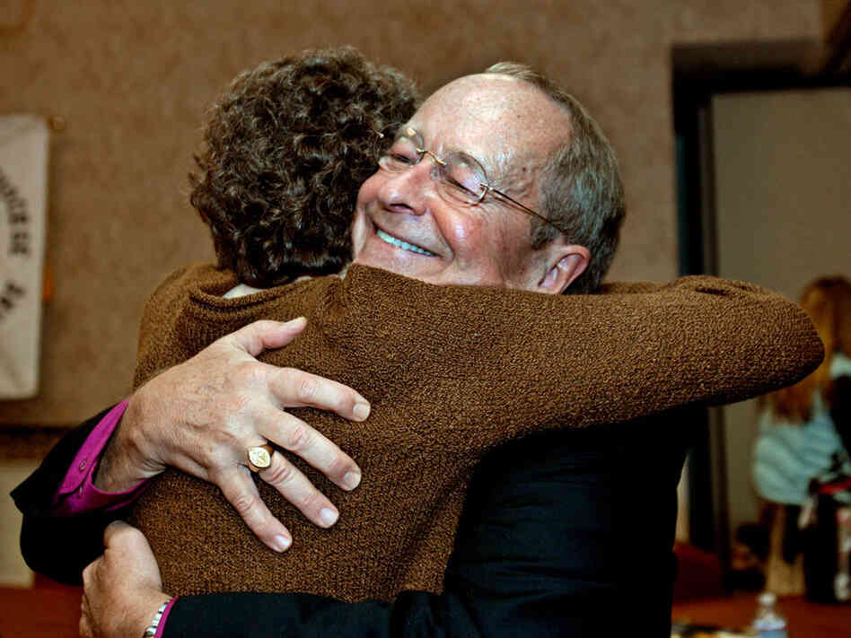 Bishop V. Gene Robinson, right, hugs a friend after announcing his retirement on Saturday.
