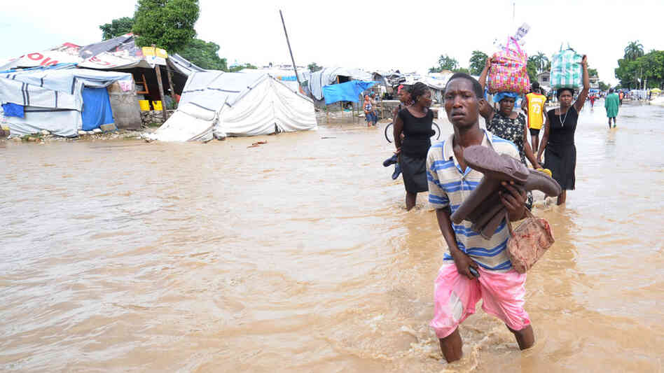 Haitians walk along a flooded road south of Port-au-Prince
