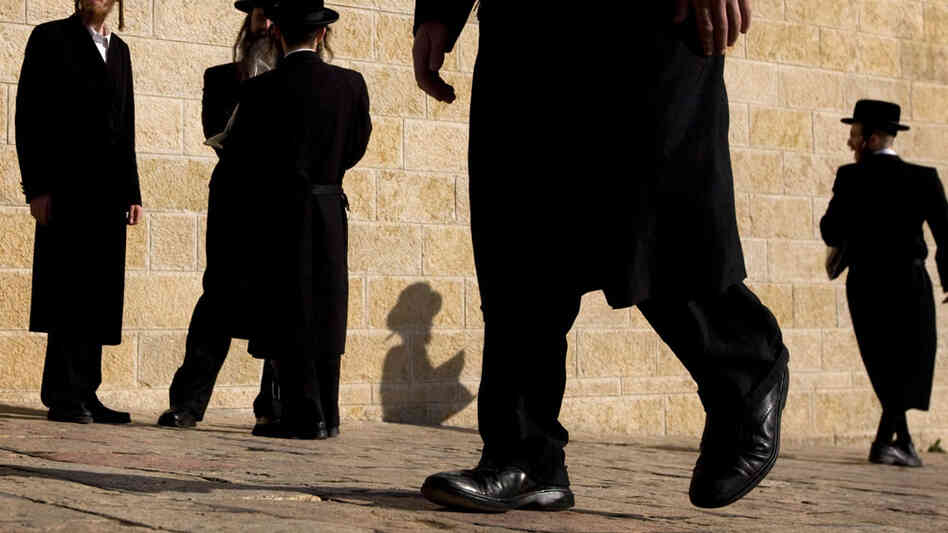 Ultra-Orthodox Jewish men walk at the Western Wall in Jerusalem.