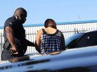 A police officer processes a young woman arrested on prostitution charges. A police officer processes a young woman arrested on prostitution charges.