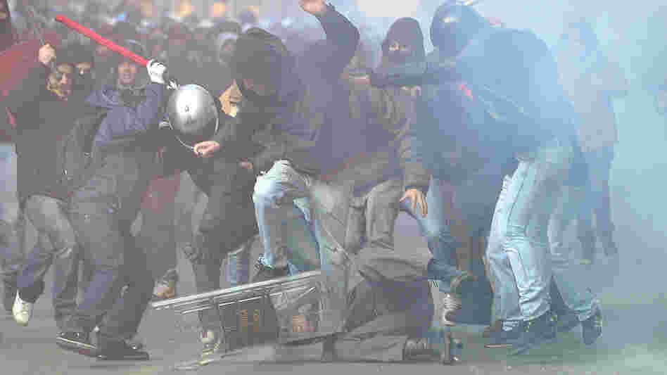protesters beat a policeman in Rome protesters beat a policeman in Rome