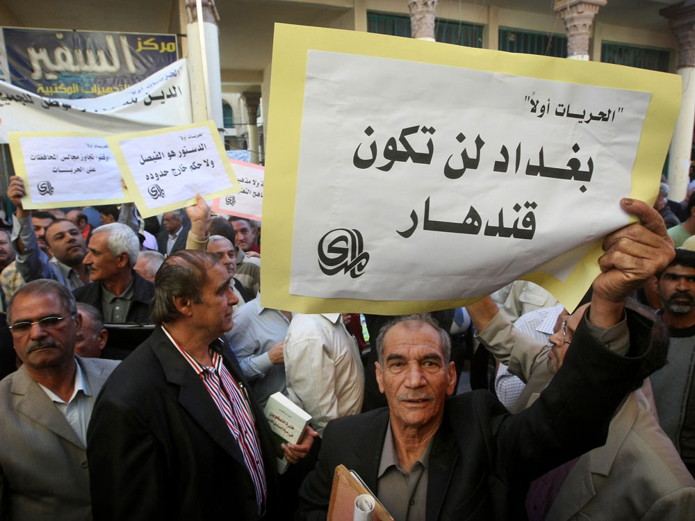 An Iraqi man holds a sign reading "Baghdad will not be Kandahar" in Arabic as he takes part in a protest in Baghdad. An Iraqi man holds a sign reading "Baghdad will not be Kandahar" in Arabic as he takes part in a protest in Baghdad.