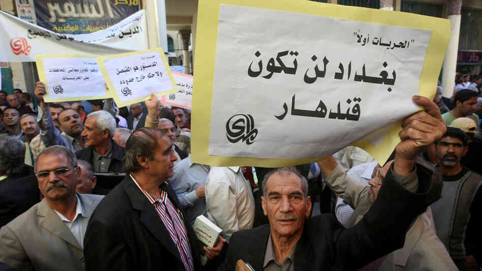 An Iraqi man holds a sign reading "Baghdad will not be Kandahar" in Arabic as he takes part in a protest in Baghdad.