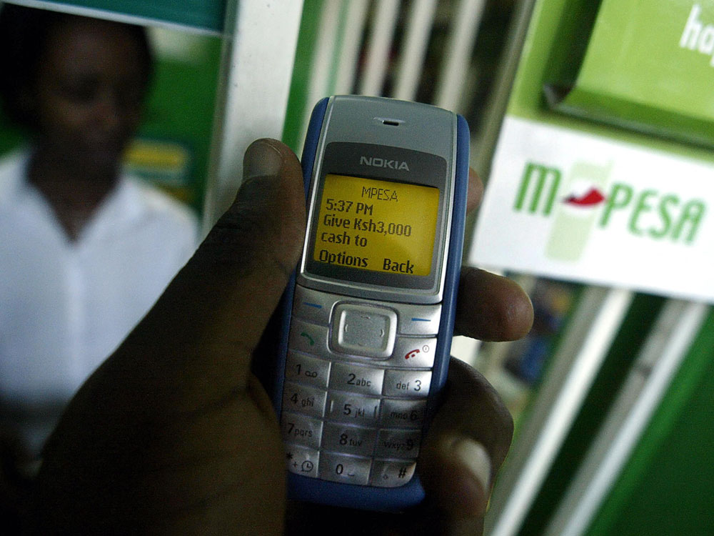 A man sends money through M-Pesa