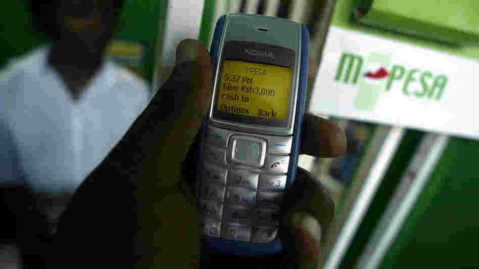 A man sends money through M-Pesa