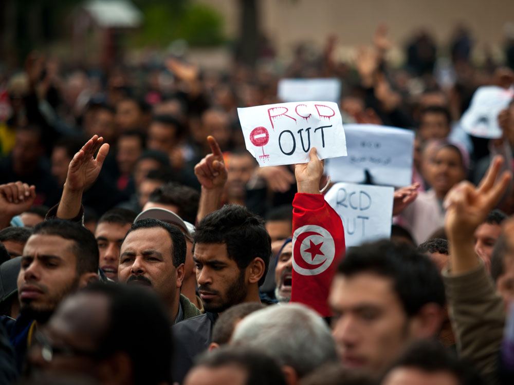 A protester holds a placard reading "RCD Out" during a demonstration outside the headquarters of ousted Tunisian President Zine El Abidine Ben Ali's Constitutional Democratic Rally party in central Tunis.