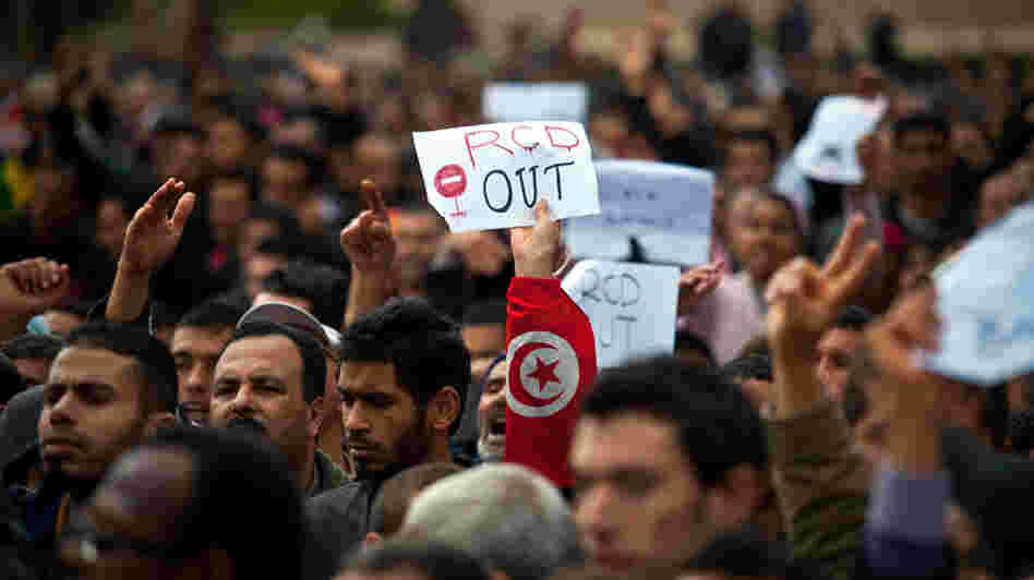 A protester holds a placard reading "RCD Out" during a demonstration outside the headquarters of ousted Tunisian President Zine El Abidine Ben Ali's Constitutional Democratic Rally party in central Tunis.