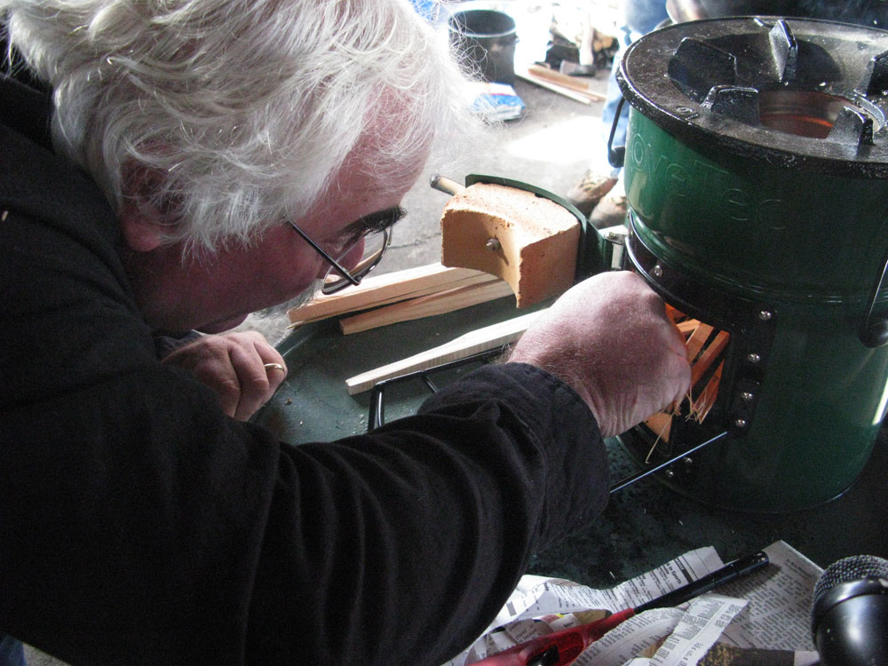 Aprovecho executive director Dean Still lights a "rocket stove." Once the fire is going, it takes only two or three sticks at a time to keep a pot of water boiling.