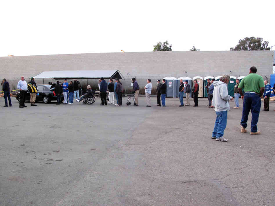 People line up to receive water from Waterman Dave. 
