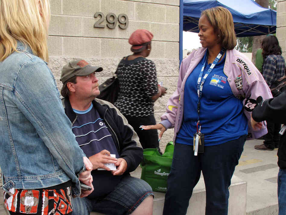 Homeless veteran Patrick Sean Williamson talks with VA social worker Marsha Latham (right) and case manager Carolyn Vahoviak (back to camera) outside a day center for homeless people in San Diego.  Williamson was homeless for about three years and suffers from diabetes.  The VA workers said they could help him find a place to live. 