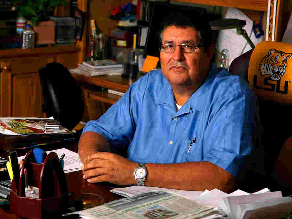 Fernando Arriola sits at the desk of the contracting business he owns.