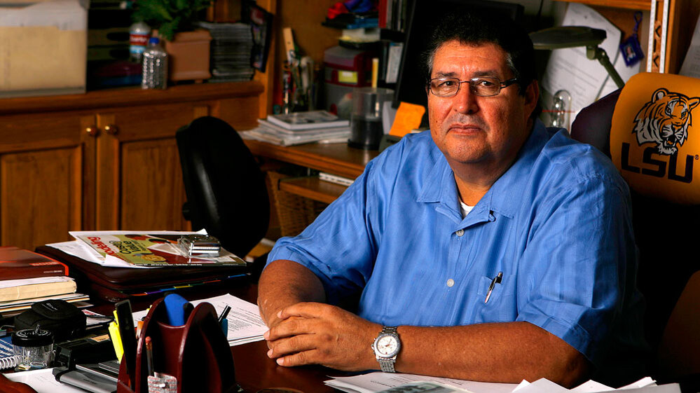 Fernando Arriola sits at the desk of the contracting business he owns.