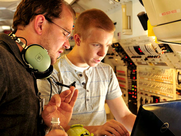 Daniel Tkacik (right) analyzes the composition of air samples sucked in from outside the plane.
