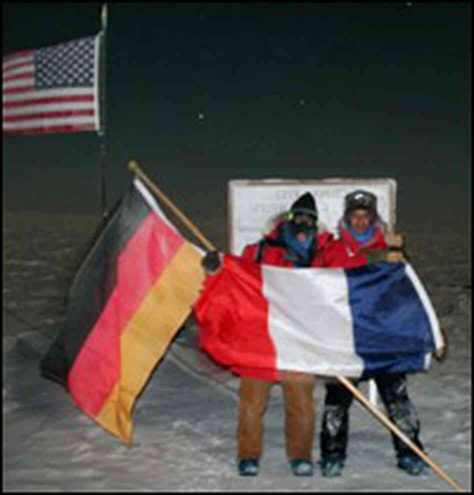Scientists at the South Pole hold up German and French flags. Scientists at the South Pole hold up German and French flags.