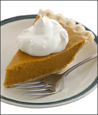 A slice of pumpkin pie with whipped cream.
