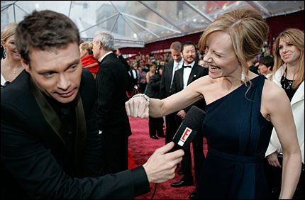 Ryan Seacrest shoves a microphone at Amy Ryan