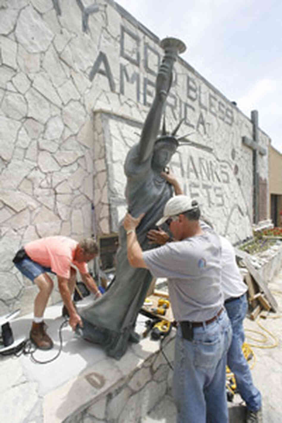workers install 8-foot statue of liberty workers install 8-foot statue of liberty