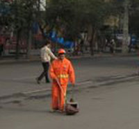 man sweeps street