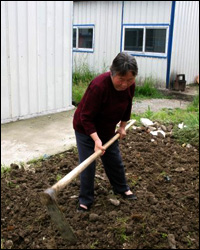 Zhou Hong Fang prepares a patch of land for planting. Photo: Melissa Block, NPR.