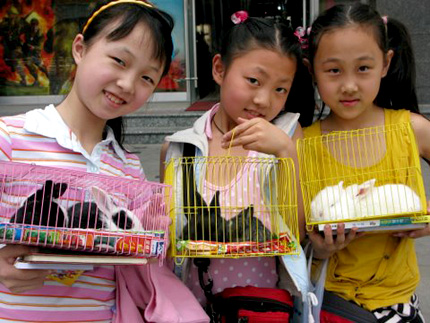 Young girls show off their bunny rabbits. Photo: Melissa Block, NPR.