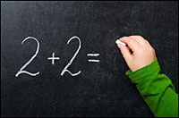 child writes 2+2= on blackboard