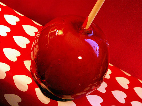 candy apple on a stick with a heart background