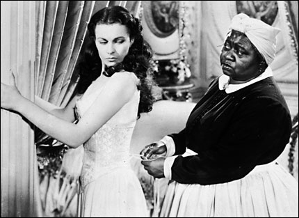 Mammy (Hattie McDaniel) laces up the stays of Scarlett O'Hara's (Vivien Leigh's) corset