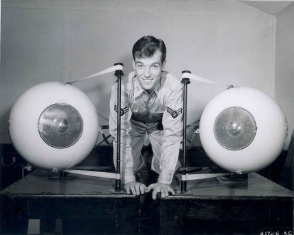 An instructor at the US Air Force School of Aviation Medicine poses with model eyeballs.