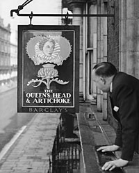 A man views a pub sign.