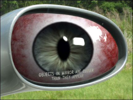 Photo illustration of giant bloodshot eye in car's side-view mirror