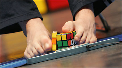 Man solving Rubik's cube with his feet