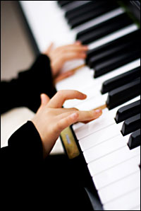 a child's hands at a piano keyboard