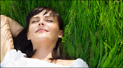A woman daydreaming in a field