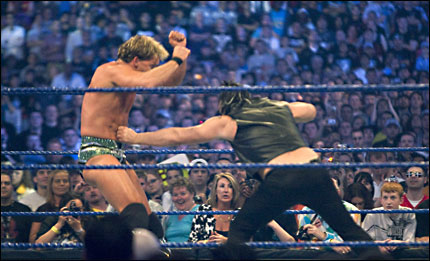 Mickey Rourke, in the ring, delivers a punch to Chris Jericho of the WWE