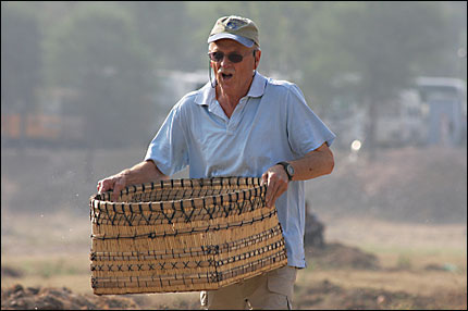 Mel White carries a heavy basket, looking tired