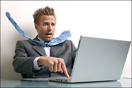 a man is very surprised by something on his computer screen