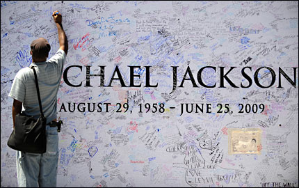 A fan writes on a memorial wall for Michael Jackson outside the Staples Center