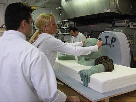 Bakers work on a cake depicting a zombie coming out of a grave on TLC's Cake Boss